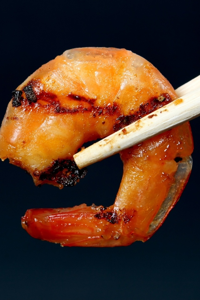 Жареная креветка с палочками на черном фоне