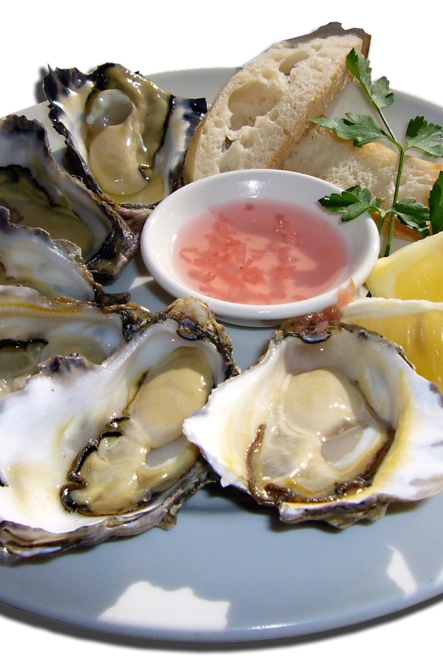 Устрицы  на белой тарелке с лимоном