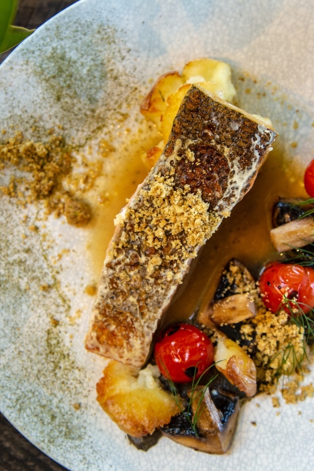 Кусок запеченной рыбы на тарелке с овощами