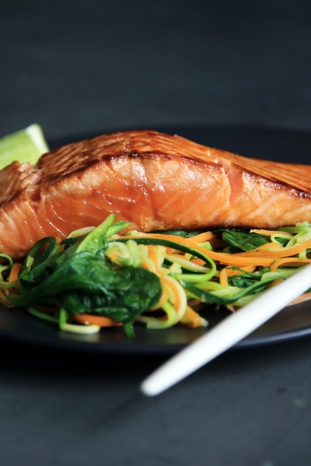 Кусок красной рыбы с салатом на тарелке