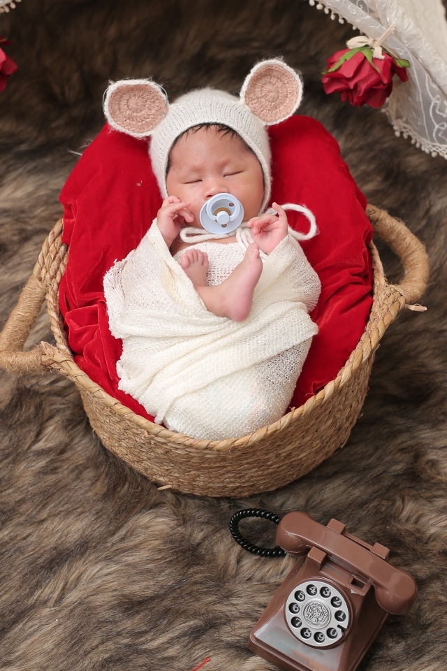 Ребенок спит в корзине с соской во рту