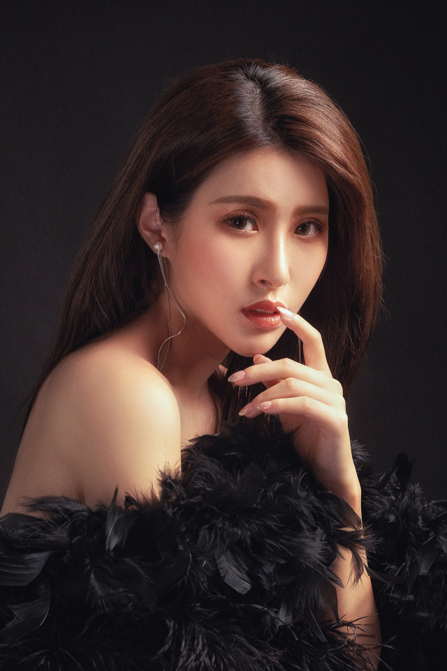 Девушка азиатка в боа на черном фоне