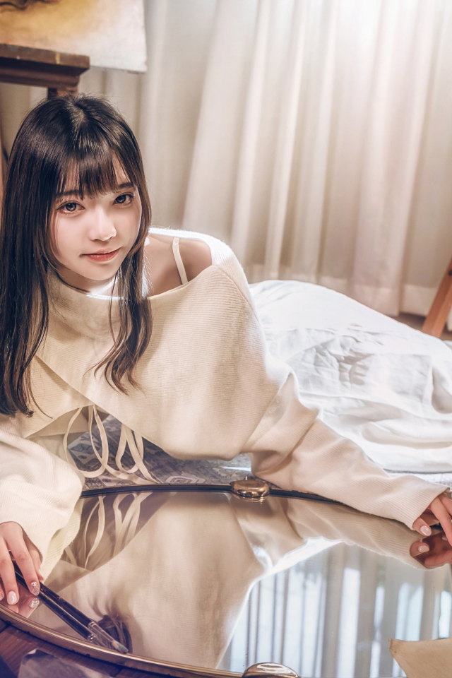 Девушка азиатка в белом платье лежит на полу