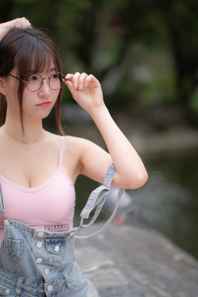 Девушка азиатка в очках и джинсовом комбинезоне