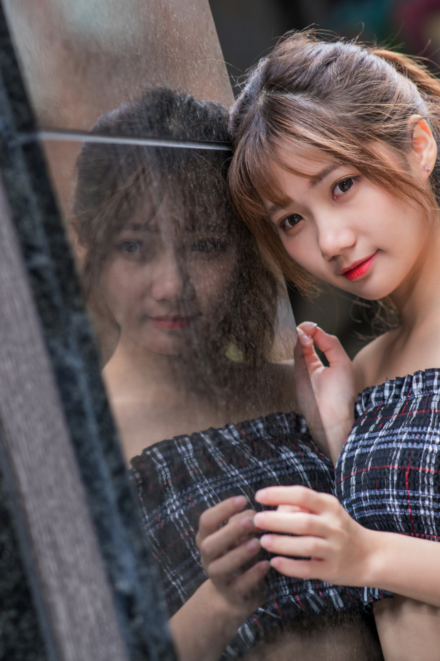 Девушка азиатка отражается в стене