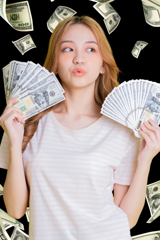 Девушка азиатка с долларами в руках