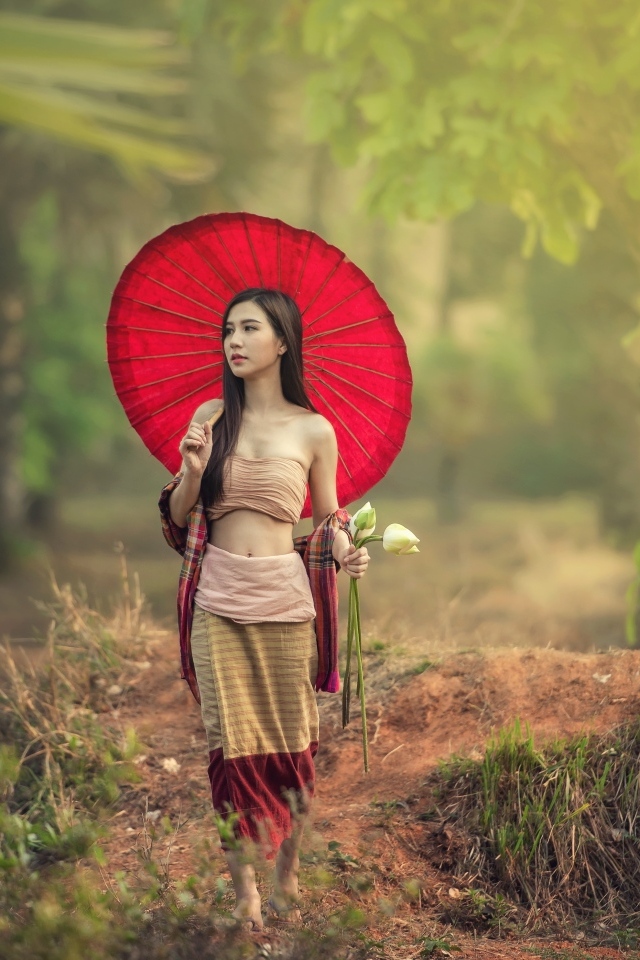 Девушка азиатка с красным зонтом и цветами лотоса