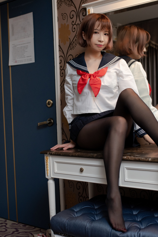 Азиатка в форме сидит на столе