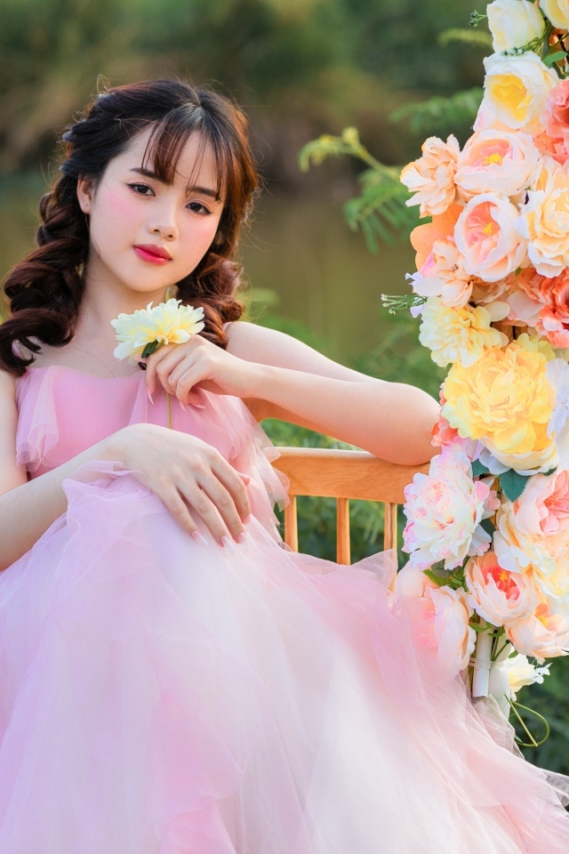 Красивая девушка азиатка в розовом платье с цветами