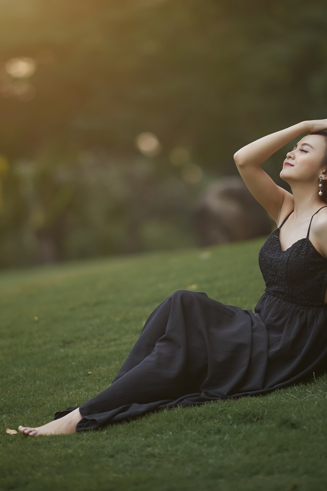 Красивая азиатка с закрытыми глазами в черном платье