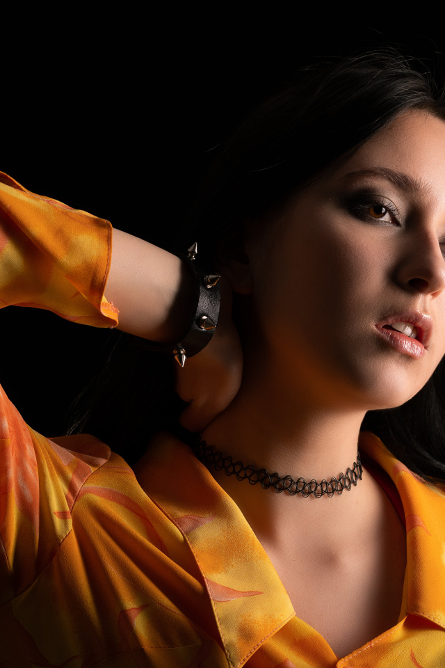 Красивая девушка шатенка с рукой в волосах на черном фоне