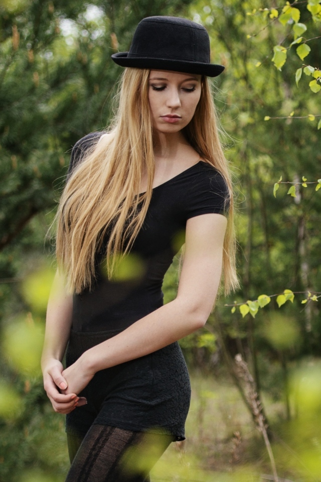Красивая девушка в черном наряде в шляпе