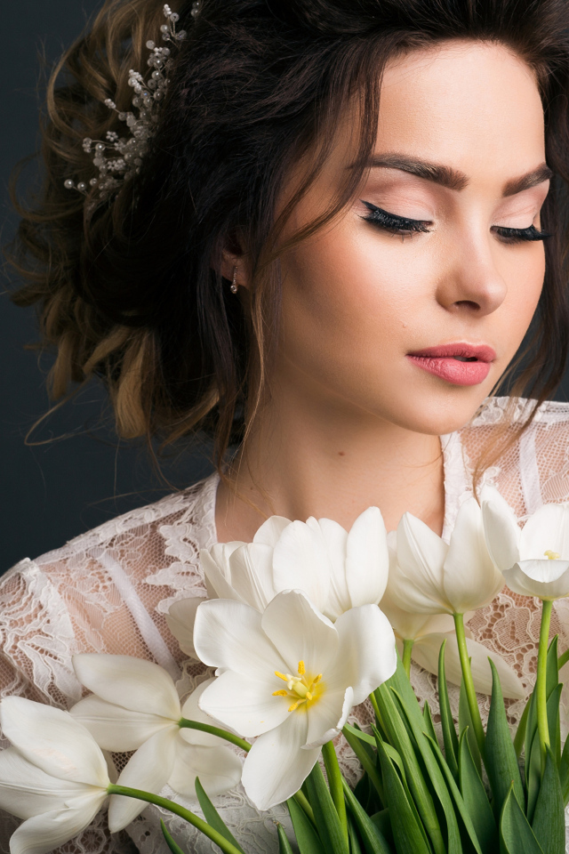 Красивая девушка с букетом белых тюльпанов на сером фоне