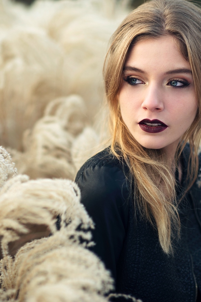 Красивая девушка с макияжем на лице позирует на природе