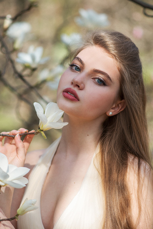 Красивая девушка с белыми цветами магнолии