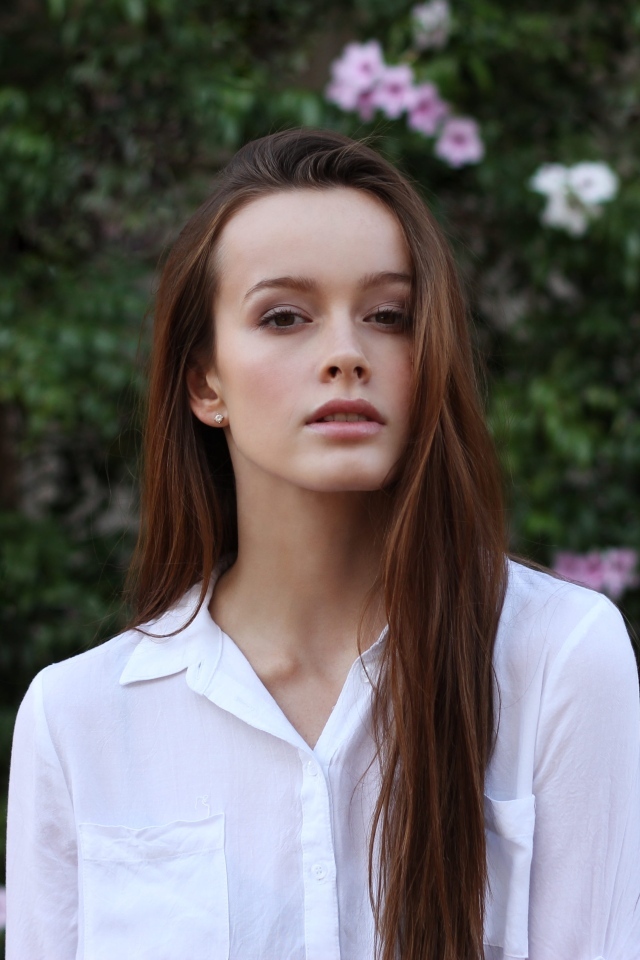 Красивая длинноволосая девушка в белой рубашке