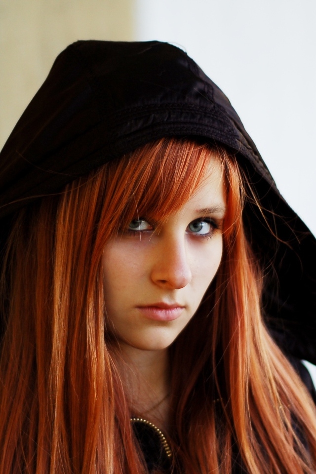 Красивая рыжеволосая девушка в черном балахоне