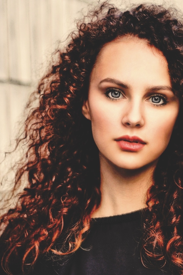 Кудрявые красивые волосы у девушки с серыми глазами