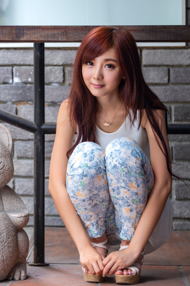 Милая девушка азиатка позирует со статуэткой