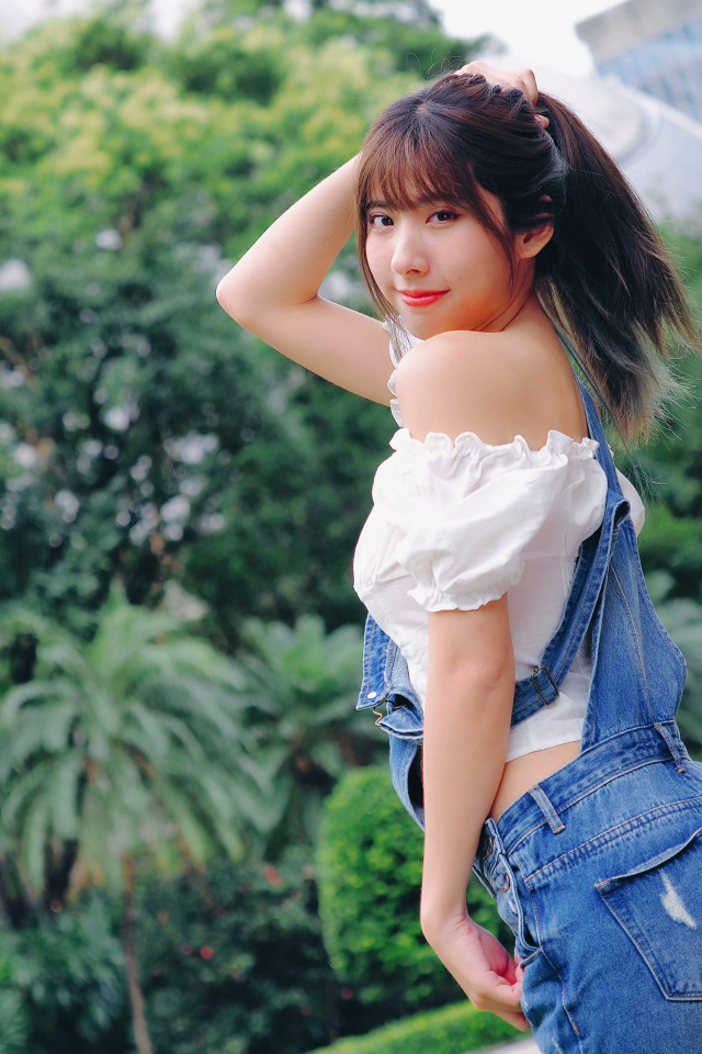 Милая девушка азиатка в джинсовом комбинезоне