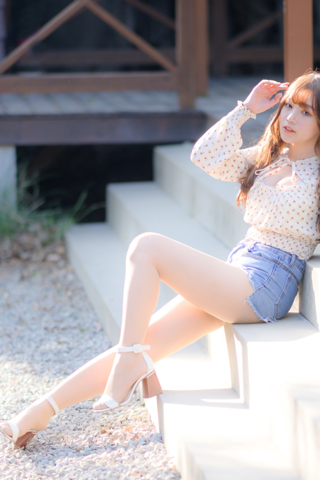 Милая настоящая азиатка сидит на ступеньках