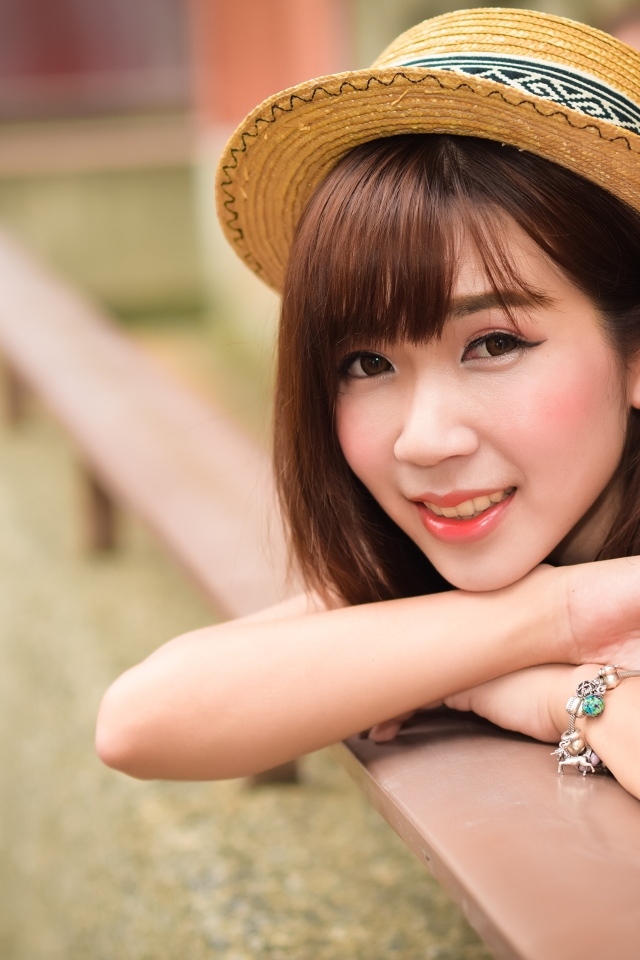 Милая улыбка азиатки в соломенной шляпе 