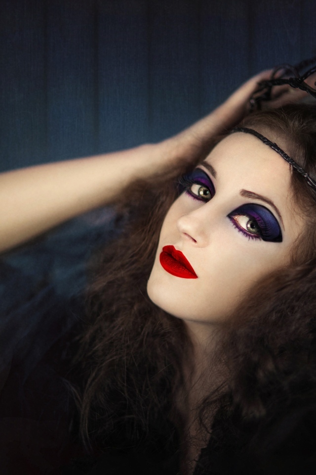 Девушка в черном наряде с ярким макияжем