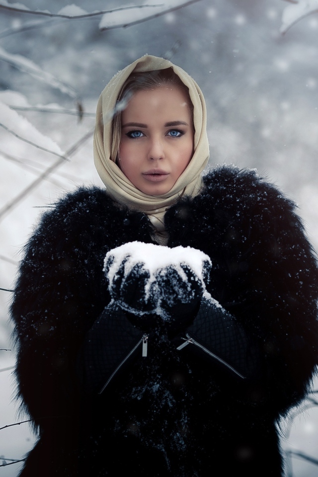 Девушка в черной шубе в заснеженном лесу