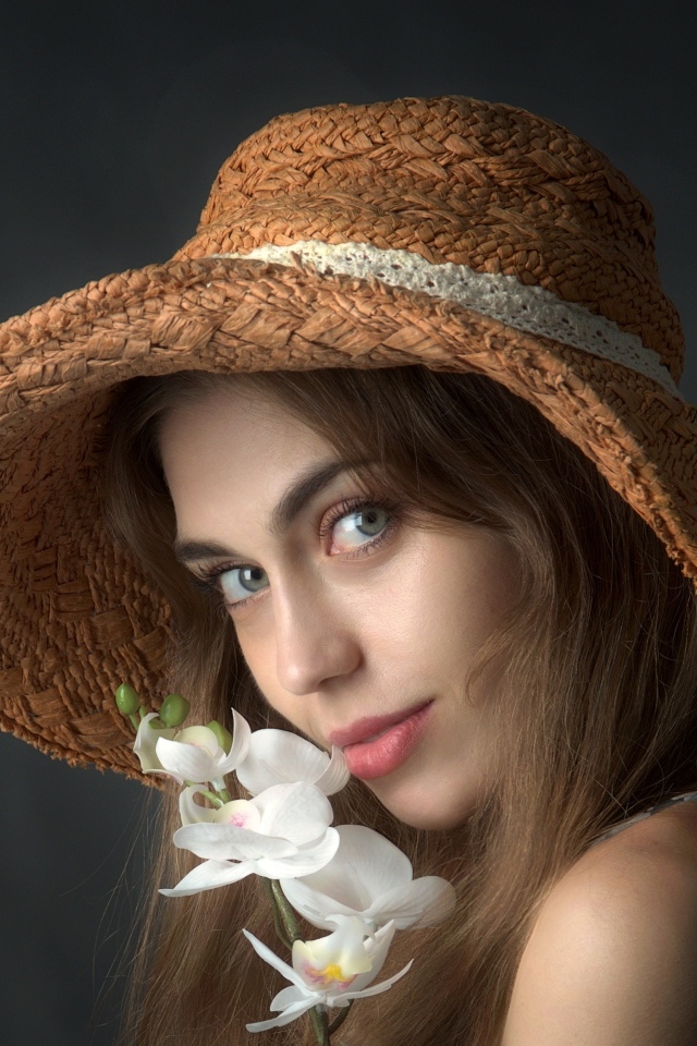 Девушка в шляпе с цветами орхидеи