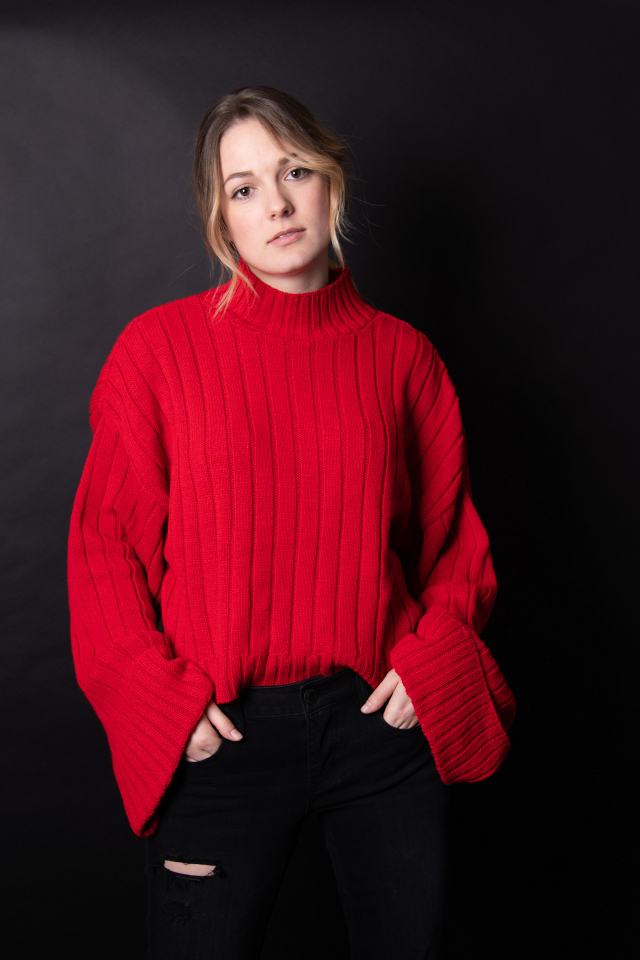 Девушка в красном свитере на черном фоне