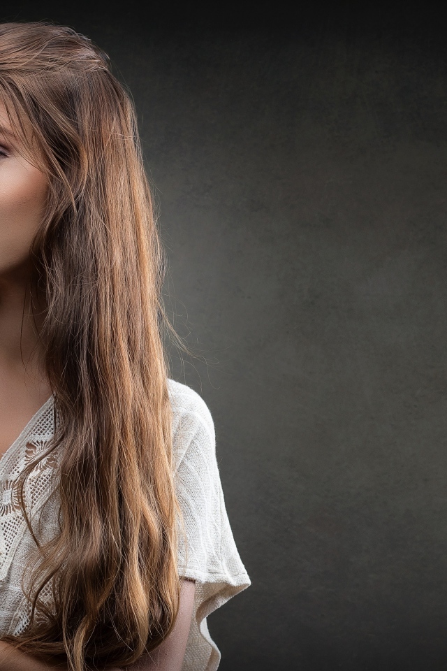 Девушка в белом платье с длинными волосами на сером фоне