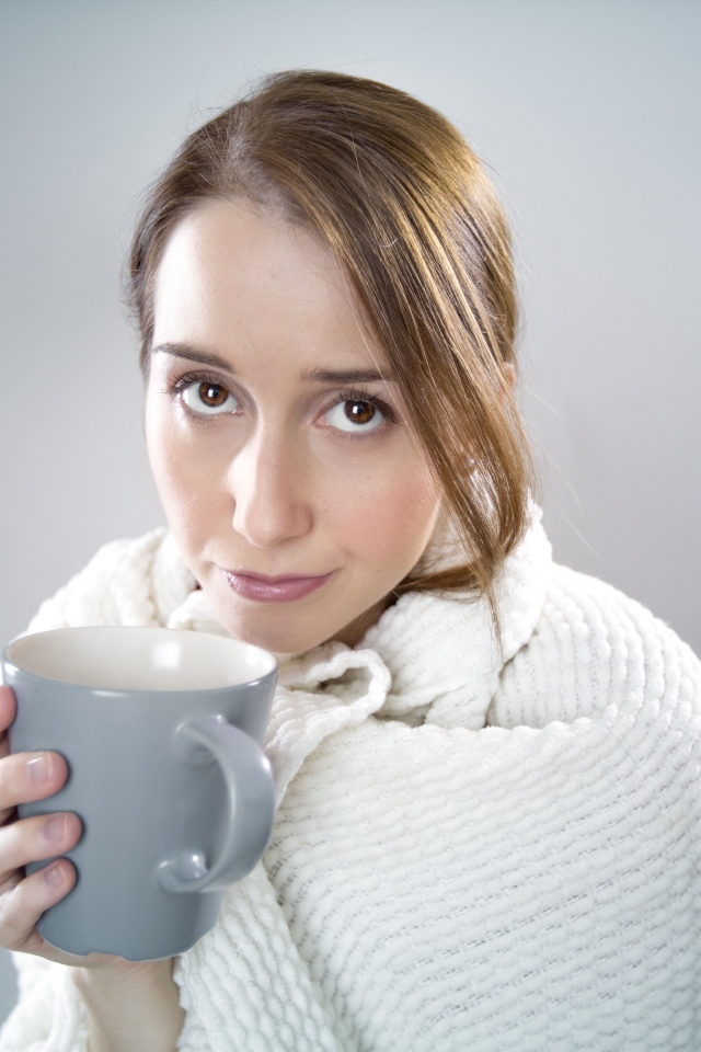 Девушка в белой кофте с кружкой в руке