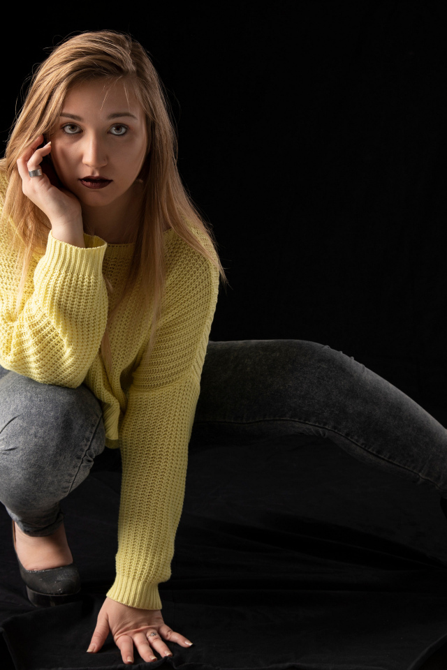 Девушка в желтом свитере на черном фоне
