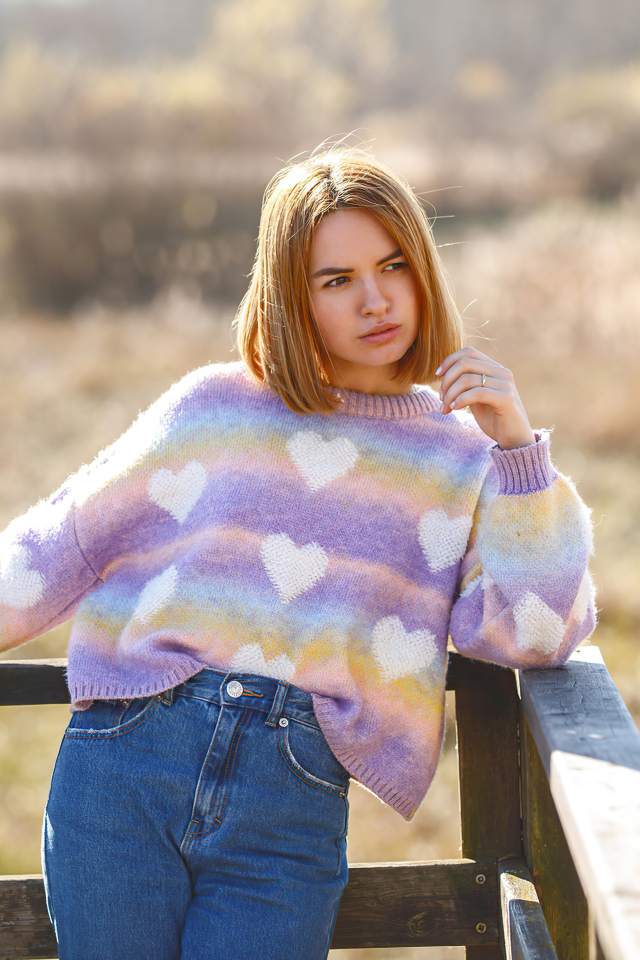 Девушка в свитере и синих джинсах