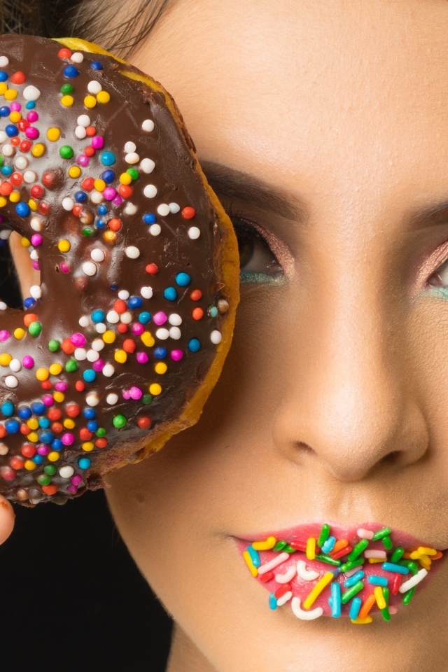 Девушка с пончиком в шоколаде в руках