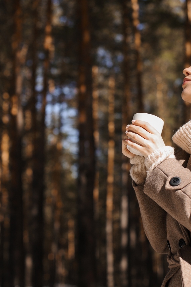 Девушка с чашкой кофе в парке