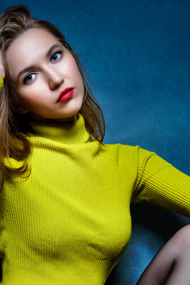 Девушка с рукой в волосах на синем фоне