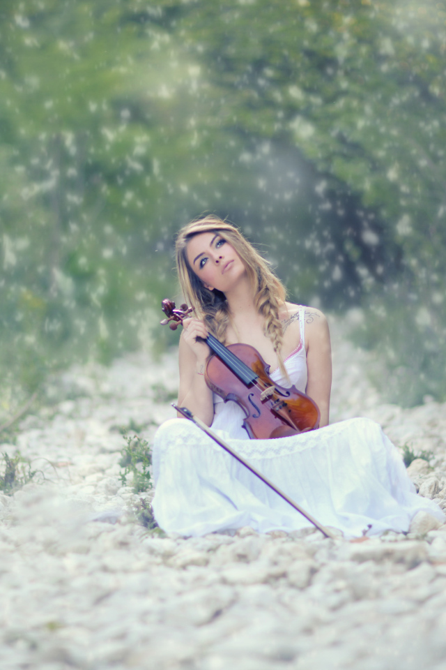 Девушка со скрипкой в руках в лесу