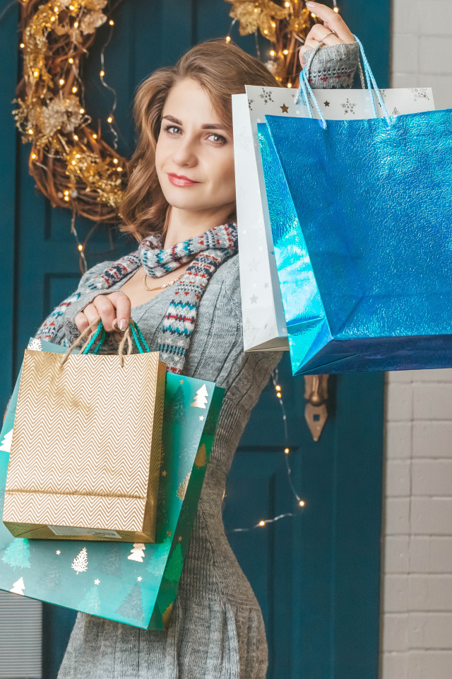 Девушка с пакетами стоит у двери