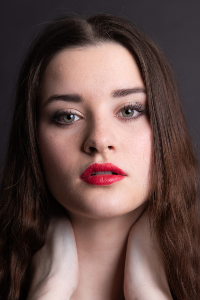 Девушка с красными губами на сером фоне