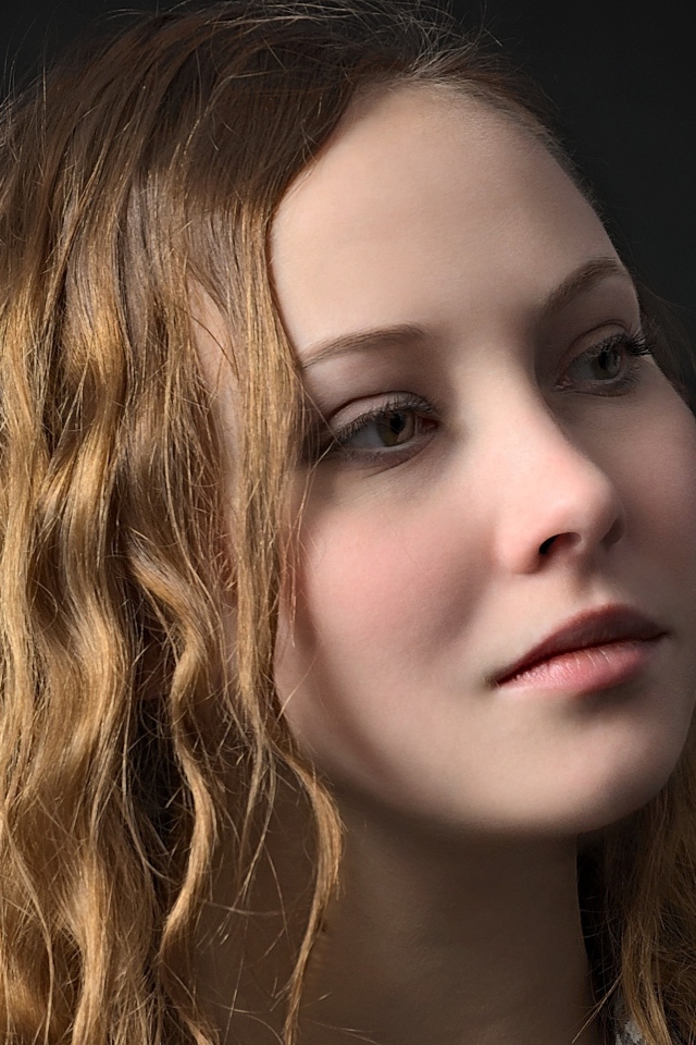 Длинноволосая кареглазая девушка на черном фоне