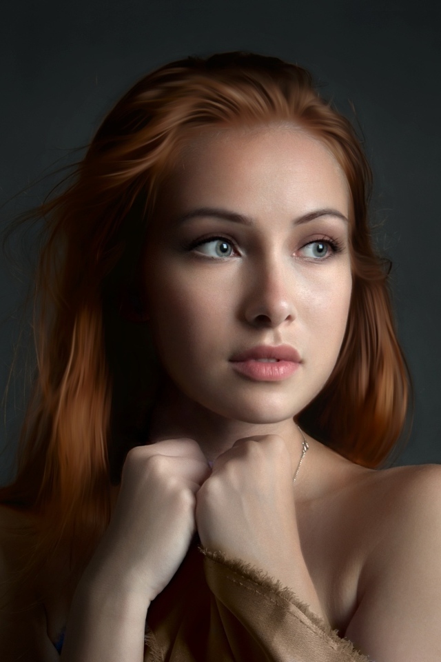 Рыжеволосая девушка с красивыми серыми глазами на сером фоне