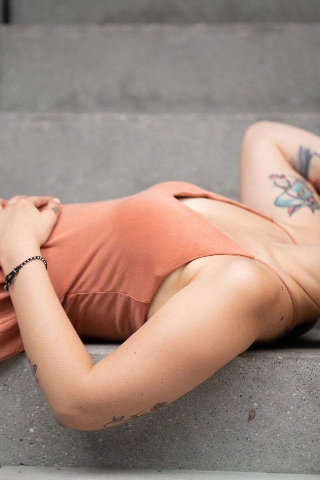 Рыжеволосая девушка с татуировками лижет на ступеньках