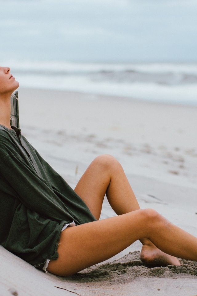 Романтическая девушка лежит на песке у моря