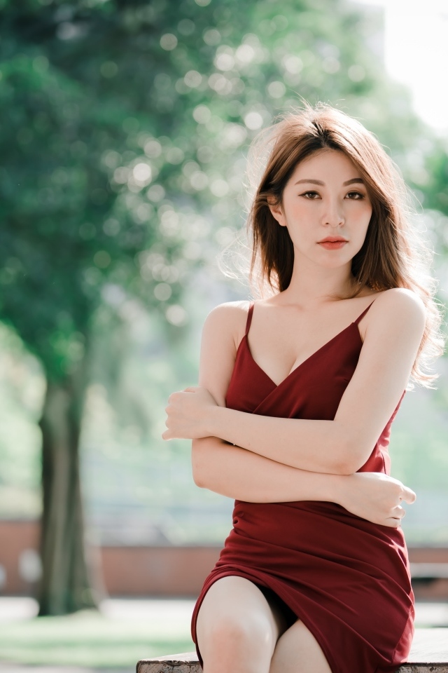 Серьезная девушка азиатка в красном платье