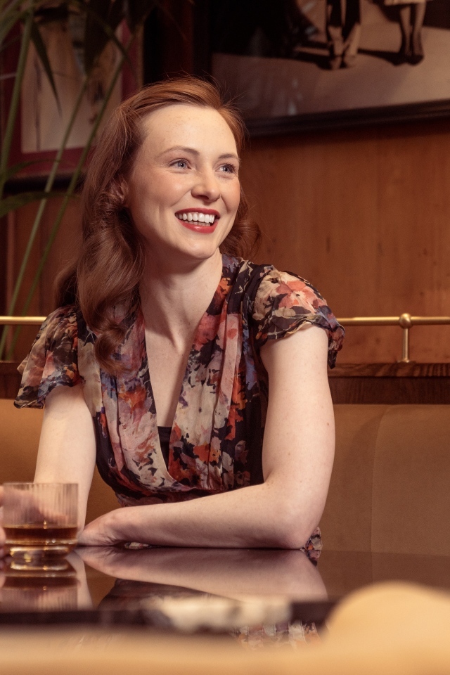 Улыбающаяся девушка за столиком в кафе