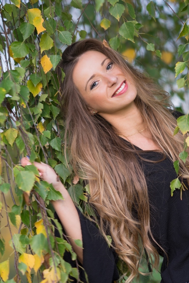 Улыбающаяся девушка в ветках березы