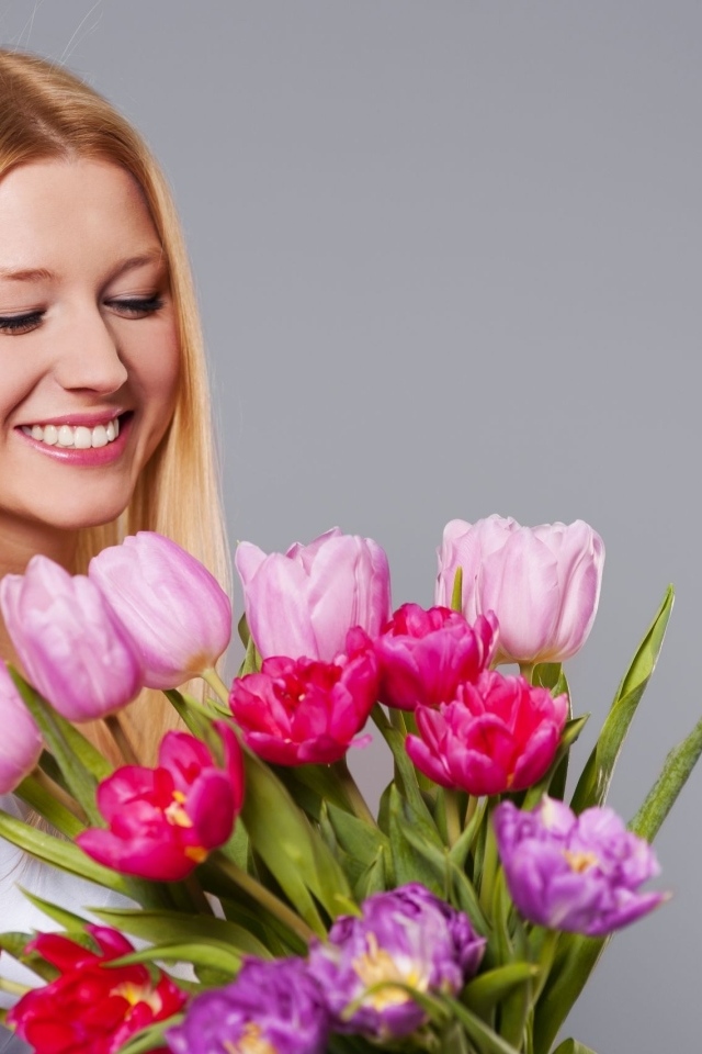 Улыбающаяся девушка с букетом тюльпанов