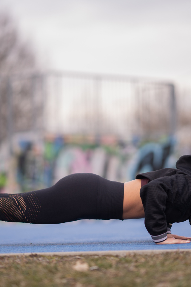 Спортивная девушка отжимается от земли