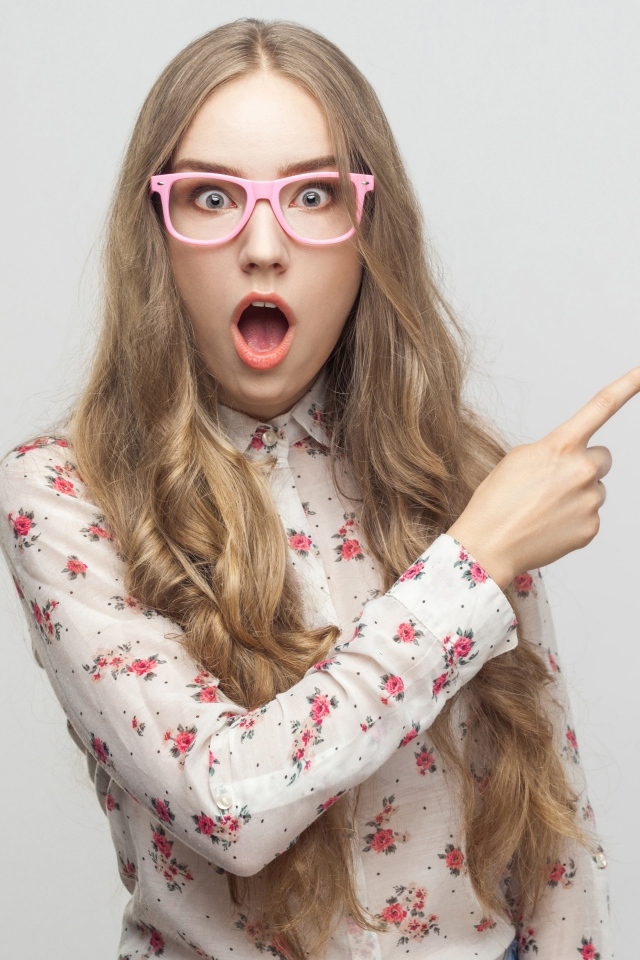 Удивленная девушка на сером фоне